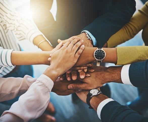 Closeup shot of an unrecognizable group of businesspeople joining their hands together in a huddle